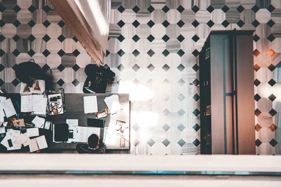 High-angle shot of a modern workspace with people and geometric patterned floor.